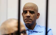 FILE: Former Libyan intelligence chief Abdullah Senussi (back) sits dressed in prison blue behind the bars of the accused cell during his trial on 28 July 2015 at court of appeals in the Libyan capital, Tripoli. Picture: AFP.