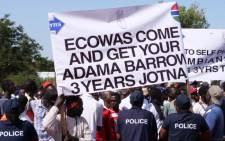 FILE: Protesters hold a banner as they take part in a demonstration against Gambian President, in Banjul, Gambia, on 16 December 2019. Picture: AFP