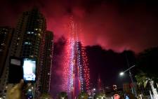 Smoke billows from the Address Downtown Hotel, after it caught on fire hours earlier, past fireworks, near the Burj Khalifa, the world's tallest tower in Dubai, on 1 January 2015. Picture: AFP/Ahmad Farwan. 