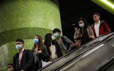 Commuters wearing face masks as a precautionary measure to protect against the possible spread of a SARS-like virus outbreak ride an escalator at an MTR subway station ahead of the Chinese New Year in Hong Kong on 23 January 2020. Picture: AFP