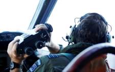 FILE: Wing Commander Rob Shearer looks through binoculars on the flight deck of a Royal New Zealand Air Force P-3K2 Orion aircraft searching for missing Malaysian Airlines flight MH370. Picture: AFP.