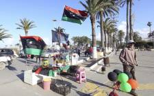 FILE: A vendor stands next to his products ahead of the eighth anniversary of the Libyan revolution which toppled late leader and strongman Muammar Gaddafi on 9 February 2019.  Picture: AFP.