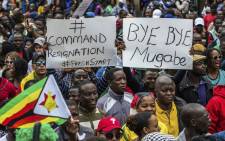 People carry placards during a demonstration demanding the resignation of Zimbabwe's former president Robert Mugabe on 18 November 2017 in Harare. Picture: AFP.