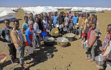 FILE: Ethiopian refugees, who fled the Tigray conflict, gather to receive aid at the Tenedba camp in Mafaza, eastern Sudan on 8 January 2021, upon their arrival at the camp from the reception center. Picture: Ashraf Shazly/AFP