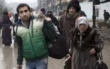 Syrians leave a rebel-held area of Aleppo towards the government-held side during an operation by Syrian government forces to retake the embattled city. Picture: AFP.