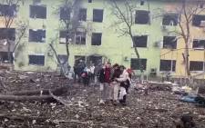 In this video grab from a handout footage taken and released by the the National Police of Ukraine on 9 March 2022, people are helped out of a damaged building of a children's hospital following a Russian air strike in the southeastern city of Mariupol. Picture: Handout/ National Police of Ukraine/AFP