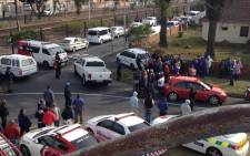 Paramedics and passersby gather at the scene where a police officer was shot in the face by a Hazendal man in Athlone on 13 May 2015. Picture: Lauren Isaacs/EWN.