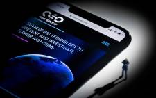 FILE: This studio photographic illustration shows a smartphone with the website of Israel's NSO Group which features 'Pegasus' spyware, on display in Paris on 21 July 2021. Picture: AFP