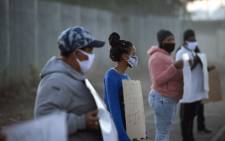 A small group of people take part in a protest outside a school in Bishop Lavis, to protest against the South African government's decision to open some schools, in Cape Town on June 1, 2020. South Africa moved into level three of a five-tier lockdown on June 1, 2020, to continue efforts to curb the spread of the COVID-19 coronavirus. Picture: AFP