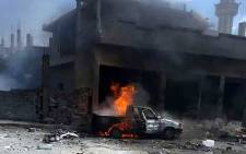 A handout image released by the official Syrian Arab News Agency on 5 May, 2016 shows a car burning at the site of a bomb attack in Mukharram al-Fawqani in Homs province. Picture: AFP.