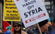 A man holds a placard during an anti-war protest after President Donald Trump launched airstrikes in Syria, 15 April 2018 in New York City. Picture: AFP