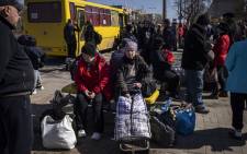 People wait for a bus to go in a train station in Severodonetsk, eastern Ukraine, on 7 April 2022, as they flee the city in the Donbas region. Picture: FADEL SENNA/AFP