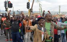 Alexandra township residents gesture and chant slogans as they clash with the Johannesburg Metro Police on 3 April 2019 in Johannesburg, South Africa during a total shutdown of the township due to a protest against the lack of service delivery. Picture: AFP