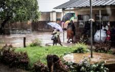 Zambian voters walk under heavy rain to join the queues at a Polling station in Lusaka, Zambia on 20 January, 2015. Picture: AFP.