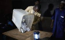 An election official overturns a box containing ballot papers during the vote counting at a polling station in Bamako on 12 August 2018, after the second round of Mali's presidential elections. Picture: AFP.




