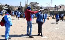 FILE: A pupil has his temperature taken at the Iphuteng Primary School in Alexandra, Johannesburg on 24 August 2020. Picture: @educationgp/Twitter
