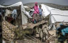 FILE: A girl and her brother stand on a donkey’s cart next to their tent at a displacement camp for people affected by intense flooding in Beledweyne, Somalia, on 14 December 2019. Picture: AFP
