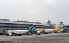 This photograph was taken on 4 September 2016 shows a Singapore Airlines subsidiary Silk Air and budget Scoot planes parked at the terminal of Changi International Airport in Singapore. Picture: AFP