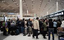 FILE: This file photo shows passengers wait for their flights at the Beijing Capital International airport after heavy snowstorm cancelled and delayed numerous flights in Beijing on 23 November 2015. Picture: AFP.

