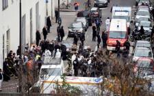 A general view shows firefighters, police officers and forensics gathered in front of the offices of the French satirical newspaper Charlie Hebdo in Paris on 7 January, 2015. Picture: AFP.