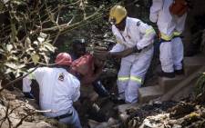 FILE: The mine rescue team helps pull an injured illegal miner out of the disused Langlaagte Gold Mine shaft entrance. Picture: AFP.