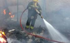 FILE: A firefighter douses flames at a Cape Town informal settlement. Picture: Regan Thaw/EWN
