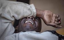 FILE: An injured man covers his face during election protests in Zimbabwe on 1 August 2018. Picture: Thomas Holder/EWN.