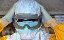 A Guinea health worker wearing a protective suit poses at an Ebola Donka treatment centre in Conakry on 8 December, 2014. Picture: AFP.