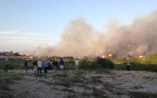 Crowds look on as houses catch alight in St Francis Bay on 11 November 2012. Picture: Supplied.
