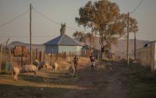 Two kids run on a dirt road Zingqolweni village on 16 May 2022. In Zingqolweni eleven people have been murdered in a year, about one a month, with clockwork regularity, earning the village of some 3,000 souls the ominous name of 'Village of Death'. Picture: Guillem Sartorio / AFP.