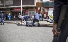 Forensic pathologists load the bodies of two South African males that were shot dead in a hostel in Jeppestown on 18 April 2015. Picture: Thomas Holder/EWN.