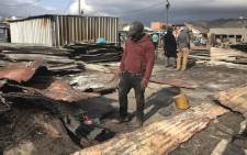 FILE: A resident walks through the rubble after a shack fire in Masiphumelele on 29 July 2019. Picture: EWN