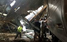FILE: Train personnel survey the New Jersey Transit train that crashed in to the platform at the Hoboken Terminal on 29 September 2016. Picture: AFP.