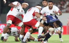 Ananaki Lelei Mafi of Japan (R) attempts to run past Tonga's players during the Pacific Nations Cup rugby union match between Japan and Tonga at Hanazono stadium in Higashiosaka, Osaka prefecture on 3 August 2019. Picture: AFP