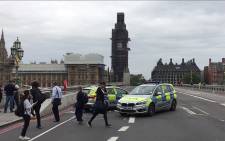 A video grab taken from AFP TV video footage shows police officers cordoning off Westminster Bridge, leading to Parliament Square in central London on 14 August 2018, after a car was driven into barriers at the Houses of Parliament. Picture: AFP.


