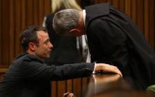Oscar Pistorius cries as he speaks to his lawyer Barry Roux during his trial at the High Court in Pretoria on 10 March 2014. Picture: Pool.