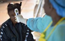 FILE: A young woman has her temperature taken during ebola outbreak in Sierra Leone. Picture: AFP