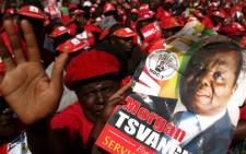 Supporters of the Movement for Democratic Change presidential candidate Morgan Tsvangirai hold his portrait as they attend the final campaign rally 'Cross Over' on 29 July 2013 at the Freedom Square in Harare ahead of the general elections held on 31 July 2013. Picture: AFP.