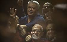 FILE: Egyptian Muslim Brotherhood leader Mohamed Badie (C-bottom) gestures from behind the defendant's cage as he attends his trial, along with ousted Islamist president Mohamed Morsi (unseen) in Cairo on 16 June 2015. Picture: AFP