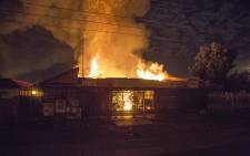 Flames rise from two shops set alight during overnight looting in Mabopane north of Pretoria on 21 June 2016. Picture: Reinart Toerien/EWN.