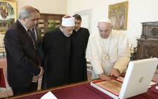 A handout photo on 4 October 2021 by the Vatican Media shows Pope Francis (R) and Egyptian Islamic scholar and the current Grand Imam of al-Azhar mosque, Sheikh Ahmed Al-Tayeb (C) exchanging gifts during a private audience at The Vatican, within the conference "Faith and Science: Towards COP26". Picture: VATICAN MEDIA/AFP