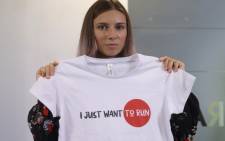Belarusian Olympic athlete Krystsina Tsimanouskaya poses with t-shirt with the lettering reading 'I just want to run' during a press conference on 5 August 2021 in Warsaw, one day after her arrival in Poland. Picture: AFP