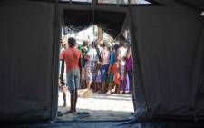 People wait in line for food at a relief camp set up for victims of Cyclone Idai who have fled to Beira. Picture: Christa Eybers/EWN