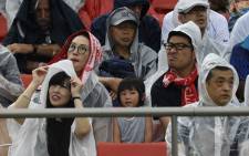 FILE: Rugby fans wear raincoats as they sit in the tribunes prior to the Japan 2019 Rugby World Cup Pool D match between Georgia and Fiji at the Hanazono Rugby Stadium in Higashiosaka on 3 October 2019. Picture: AFP.