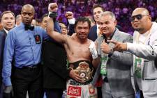 Manny Pacquiao poses with members of his team and referee Kenny Bayless after defeating Keith Thurman by split decision in a WBA welterweight title fight at MGM Grand Garden Arena on 20 July. Picture: AFP.