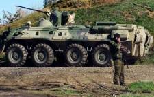 FILE: Russian troops stands guard in front of an APC at a check-point in Crimea. Picture: AFP.