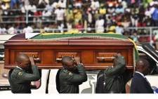 The casket containing the body of Zimbabwe's late former President Robert Mugabe is hoisted by soldiers in ceremonial uniform after it arrived on 12 September 2019 at the historic Rufaro Stadium in the capital, Harare, where his body will lie in state for members of the public file past. Picture: AFP