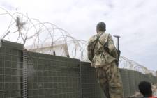 FILE: A Somali army soldier looks over a fence during an attack on the Somali parliament in Mogadishu on 24 May, 2014. Picture: AFP.