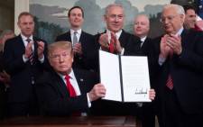 US President Donald Trump holds up a signed Proclamation on the Golan Heights alongside Israeli Prime Minister Benjamin Netanyahu in the Diplomatic Reception Room at the White House in Washington, DC, 25 March 2019. Picture: AFP