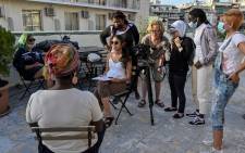 Young refugees and Greek women film during an interview on gender-based violence with Loretta Macauley, from African Women Organization Greece in Athens on 25 May 2021. Picture: LOUISA GOULIAMAKI/AFP